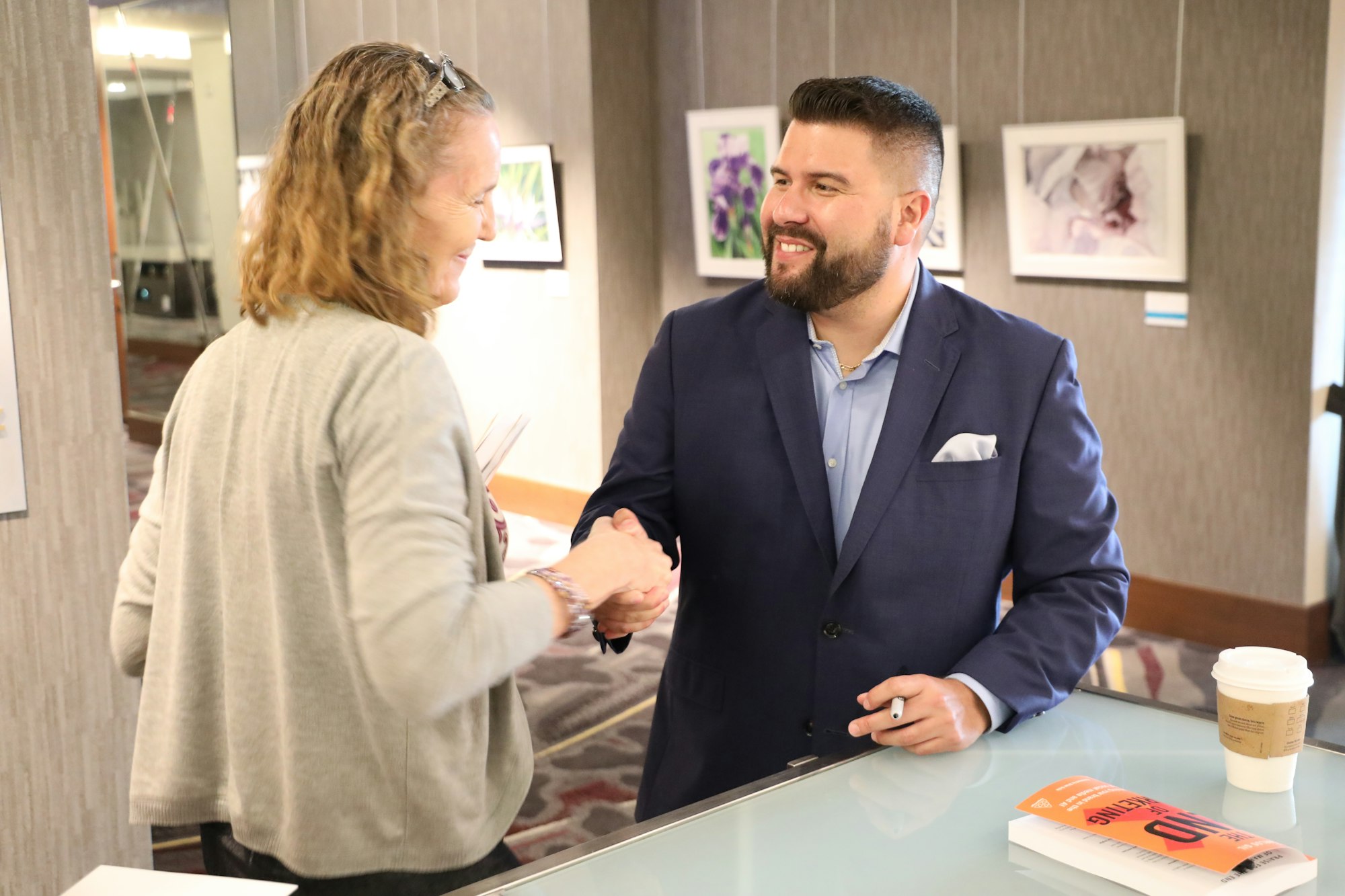 A handshake across a hotel reception desk