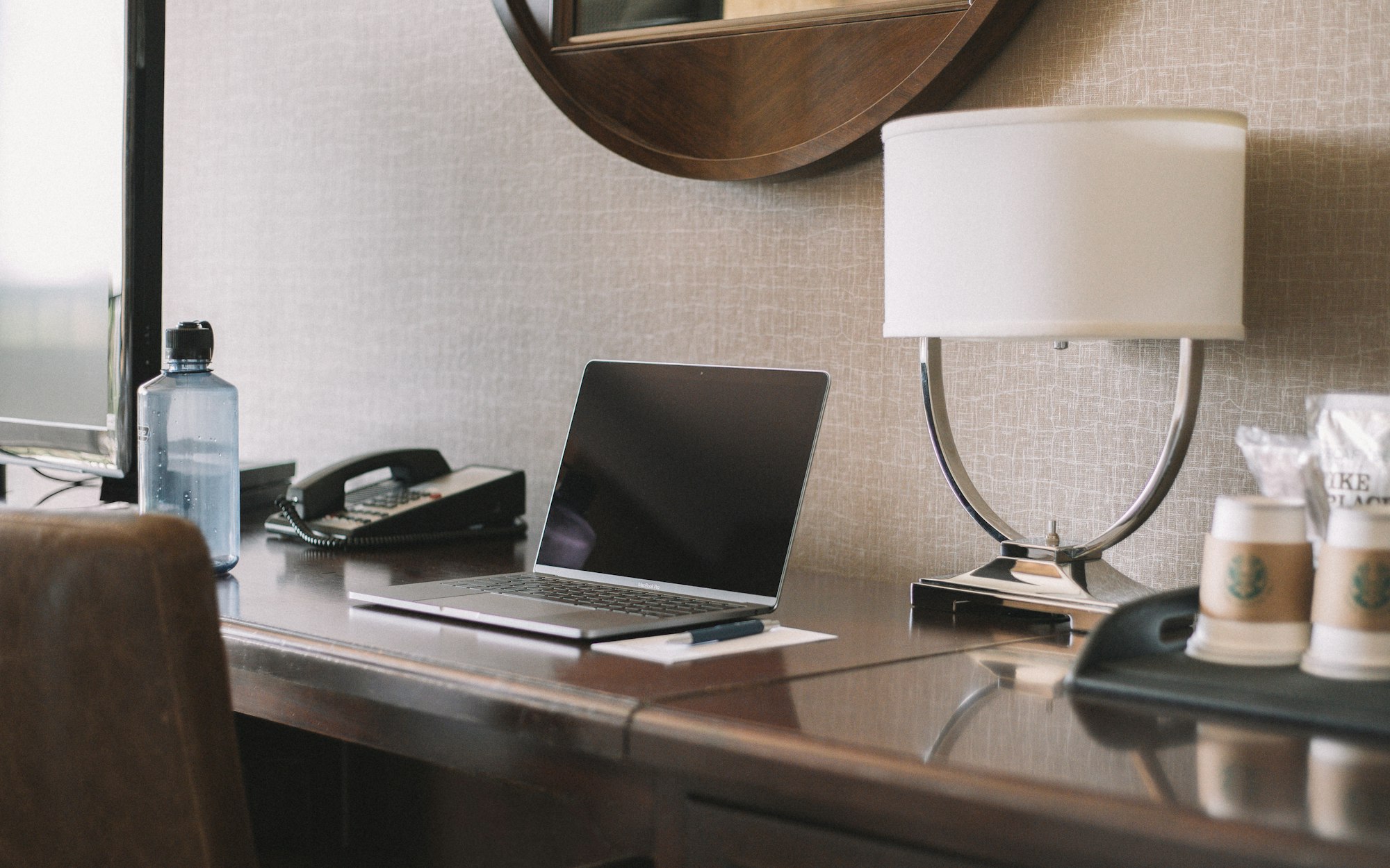 A hotel manager working on a laptop at the front desk